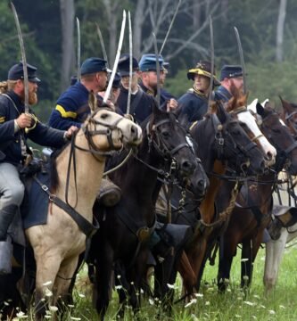 men riding horses on green grass field during daytime